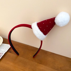 Détail d'un serre-tête bonnet de Noël en velours rouge avec paillettes et pompon en fausse fourrure