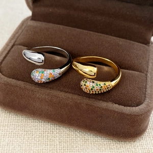 Dettaglio di anelli incrociati placcati in oro 18 carati e argento con zirconi