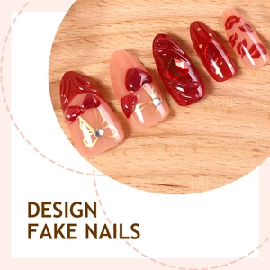 3D almond fake nails set with red hearts, gold bows, and sparkling rhinestone charms