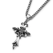 Detailed view of gothic silver cross pendant with crown and fleur-de-lis engravings