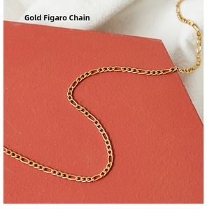 Detail of a gold Figaro chain necklace on a red display board with intricate links