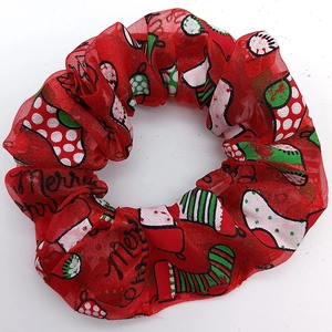 Close-up of red mesh hair scrunchie with Merry Christmas print and festive patterns