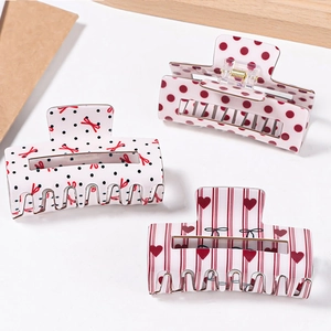 Three-piece hair claw set with polka dots, bows, and heart patterns in a stylish design