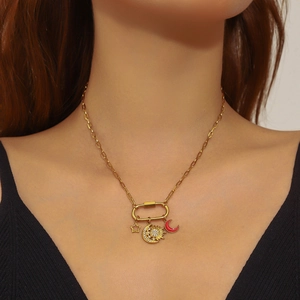 Close-up of golden paperclip chain necklace with sun moon and star charms on model