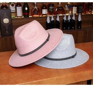 Detail of pink and gray wool fedora hats with studded bands on a wooden bar counter