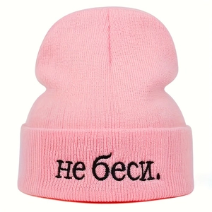 Pink knitted beanie with black 'не беси' embroidery featuring a casual cuffed design