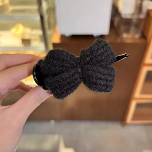 Detailed view of a black knitted bow hair claw clip with high-quality fabric texture