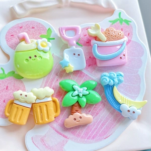 Detailed flat lay of summer beach resin charms including coconut drink and palm tree icons
