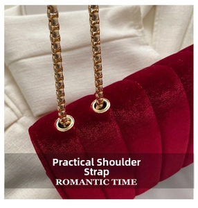 Detail of red velvet shoulder bag featuring gold chain and vertical quilted texture