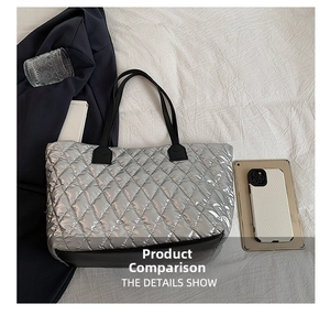 Detail showing the quilted silver puffer tote with black reinforced bottom and sturdy handles