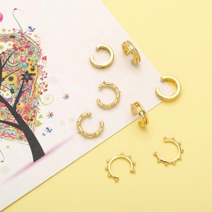 Detailed macro shot of 8-piece gold vintage non-pierced ear cuff set on artistic card