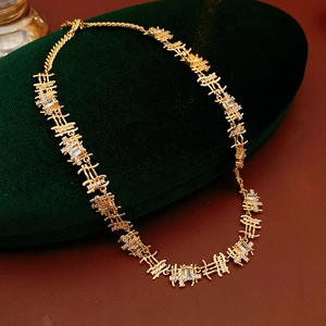 Gros plan d'un collier doré avec pendentif carré en zircon sur support en velours