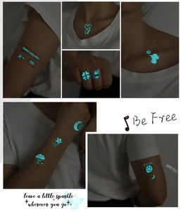 Luminous blue tattoos showing cat, moon and elephant patterns on skin in dark setting