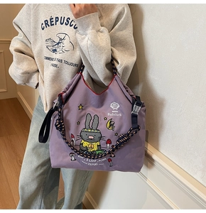 Close-up of purple canvas tote bag featuring cute rabbit print and braided rope handle