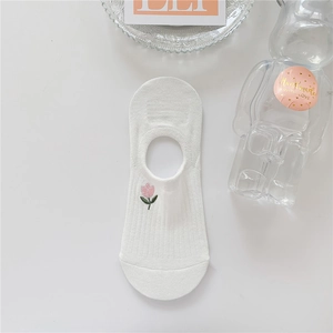 Detail of white cotton no-show sock featuring pink tulip embroidery and ribbed texture