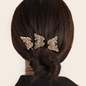 Three golden hollow butterfly hair clips on a female model elegant updo hairstyle
