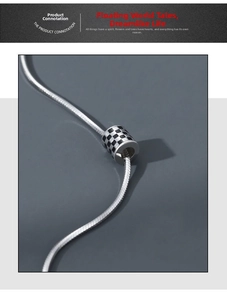 Macro shot of silver stainless steel snake chain with a black and white checkerboard pendant