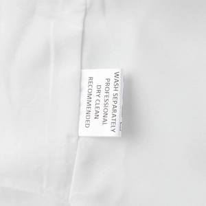 Gros plan de l'étiquette d'entretien sur une robe en coton blanc avec instructions