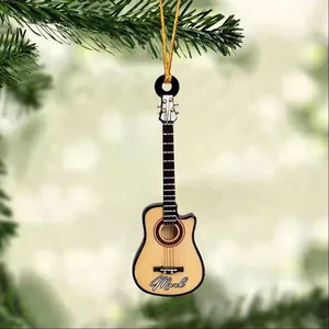 Close-up of guitar-shaped acrylic ornament with Mark name on a green Christmas tree