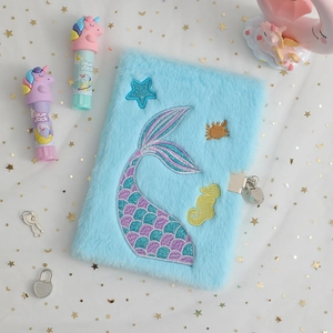 Detail of blue plush A5 diary with mermaid tail embroidery and metal lock with keys
