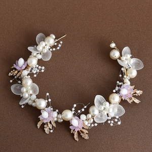 Detail of bridal headband featuring pearls, purple flowers and golden wire craftsmanship