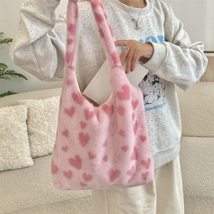 Close-up of fluffy light pink plush tote bag with heart patterns and spacious interior