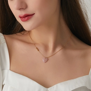 Gold stainless steel necklace with pink crystal heart pendant and Lucky tag on model