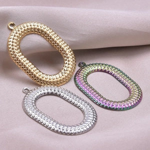 Detailed view of oval hammered DIY charms in gold, silver, and rainbow steel