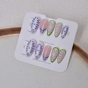 Close-up of semi-handmade floral almond press-on nails with 3D petals and pearls