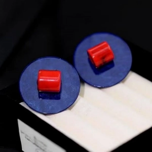Vue détaillée des boucles d'oreilles rondes bleues avec centre rouge et design minimaliste