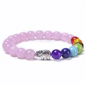 Detail of pink natural stone beads and silver elephant charm on elastic yoga bracelet