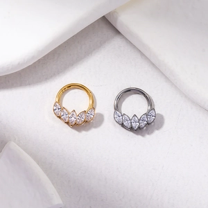 Detailed macro view of gold and silver titanium nose rings with marquise cut zircon fan