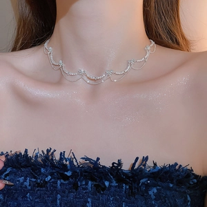 Close-up of sparkling zircon butterfly choker with dangling tassels on woman neck