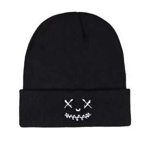 Classic black knitted beanie featuring white embroidered cross eye graphic for winter