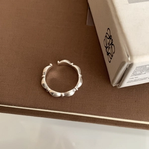 Macro shot of segmented bamboo style S925 sterling silver ring on a textured surface