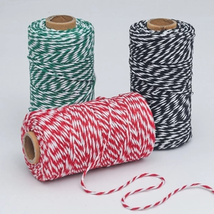 Three rolls of Christmas cotton baker twine in red, green, and black with white patterns