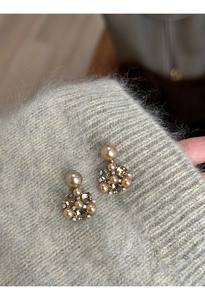 Macro shot of geometric flower earrings with champagne pearls and brown crystals