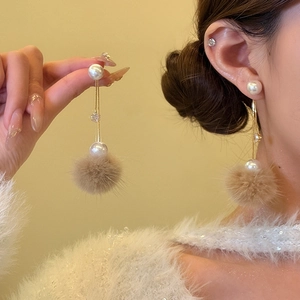 Boucles d'oreilles pendantes dorées avec perles, pompons en fourrure et détails en zircon