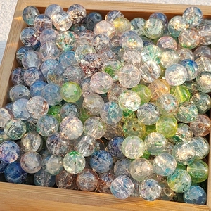 Mixed color ice-cracked glass beads with gold foil effect in a wooden tray for jewelry DIY