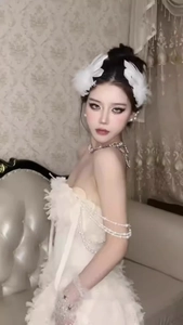 Detail of white swan feather hair clip with pearl embellishments on a vintage style model