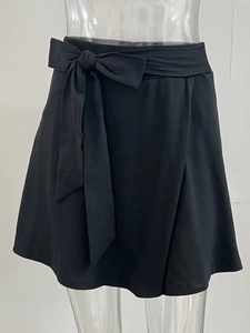 Détail de la jupe de yoga plissée noire avec taille ajustable à cordon et nœud élégant