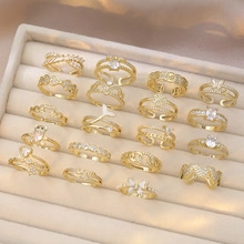 Detail of diverse gold butterfly and heart ring set arranged in a jewelry box storage