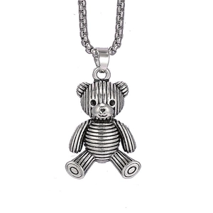 Detailed macro view of vintage silver teddy bear pendant with striped metal texture