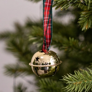 Polished gold Christmas bell with star cutouts hanging on a festive tree branch