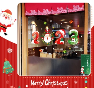 Detail of 2023 Christmas glass stickers with Santa Claus and snowflakes on a shop door