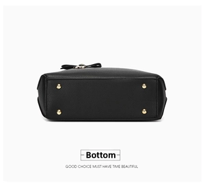 Detailed bottom view of black pebble leather handbag with four gold protective metal feet