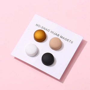 Set of four multi-color magnetic hijab pins in gold and black on a minimalist display card