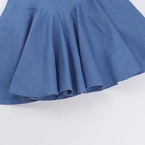 Vista dettagliata dell'orlo svasato di gonna in denim blu con trama in maglia di qualità