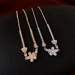 Detail of flower charm bracelets in gold and silver finish with micro-pave cubic zirconia