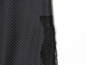 Détail du haut noir à pois blancs avec des finitions en dentelle délicate au bord